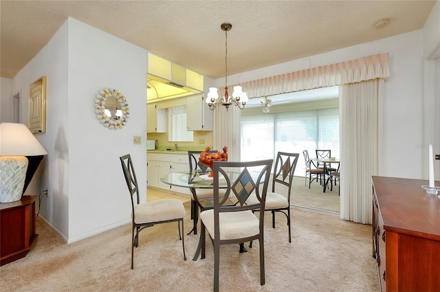 carpeted dining room with a notable chandelier, a textured ceiling, and sink