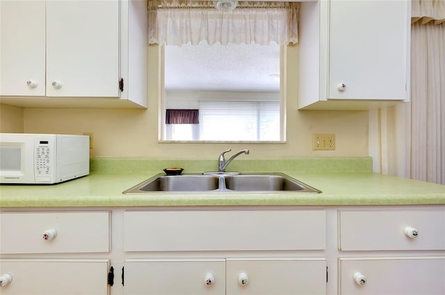 kitchen with white cabinetry and sink