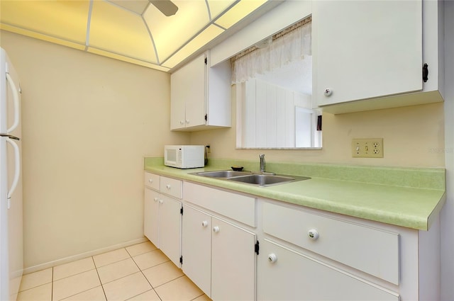 kitchen with sink, white appliances, white cabinetry, and light tile floors