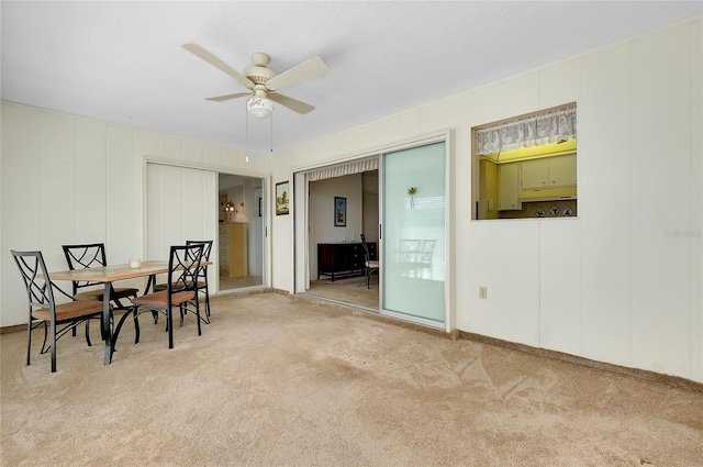 dining room with light carpet and ceiling fan