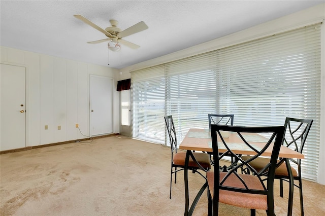 dining room with ceiling fan and light colored carpet