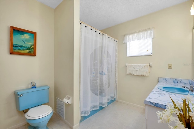 bathroom with tile floors, a textured ceiling, toilet, and vanity