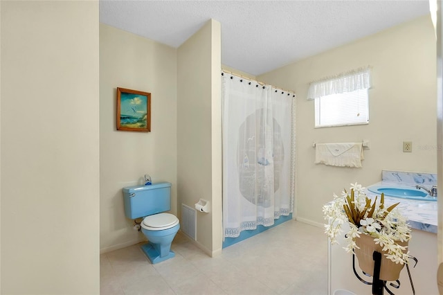 bathroom featuring tile floors, a textured ceiling, sink, and toilet