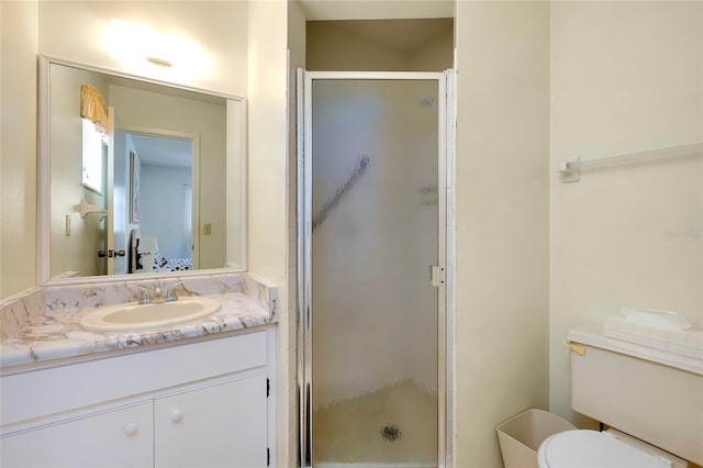 bathroom with a shower with door, toilet, and large vanity