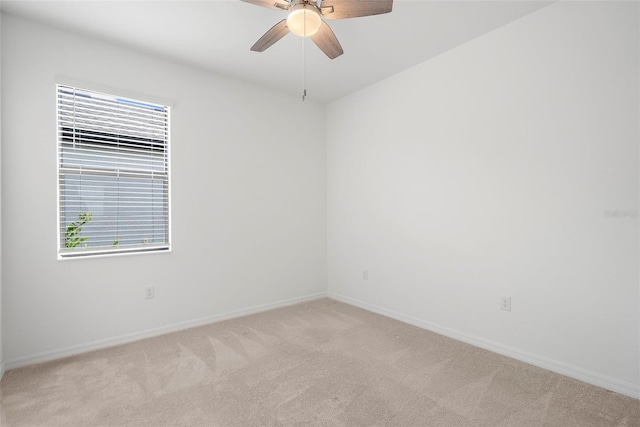 empty room with ceiling fan and light carpet