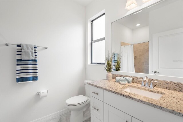 bathroom featuring plenty of natural light, toilet, vanity, and walk in shower