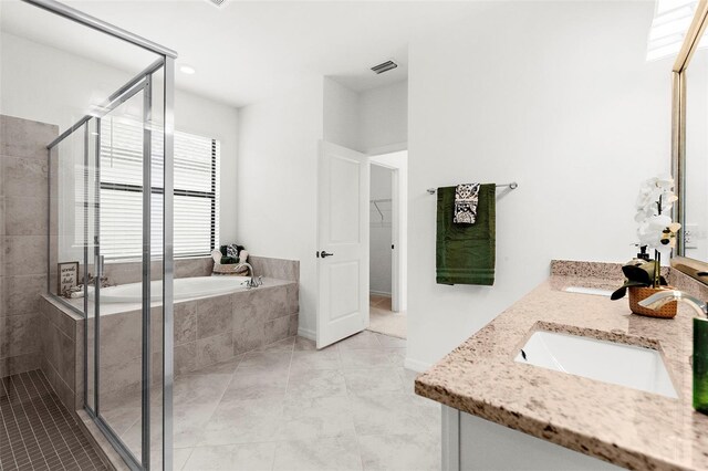 bathroom with tile patterned floors, shower with separate bathtub, and vanity