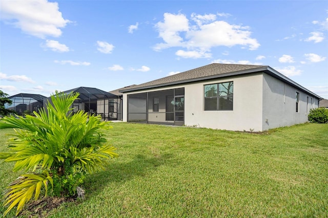 rear view of property with glass enclosure and a yard