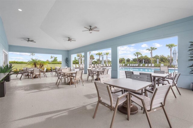 view of patio with a community pool and ceiling fan