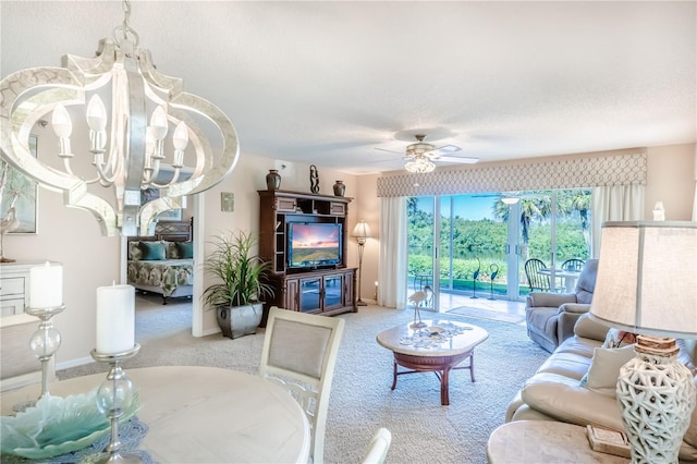 living room featuring a textured ceiling, ceiling fan with notable chandelier, and light colored carpet