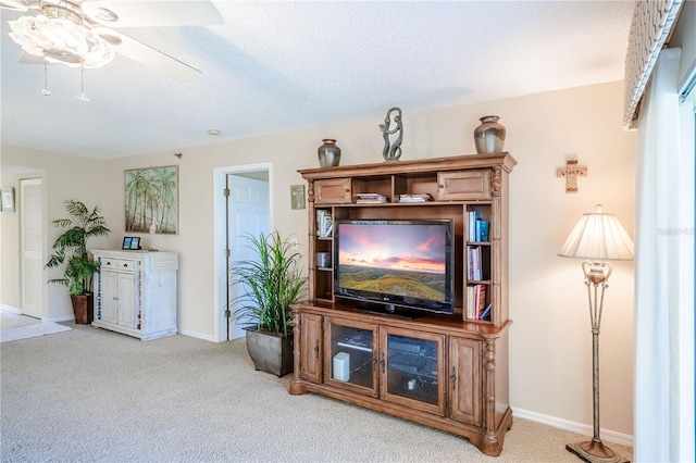 living room with ceiling fan, carpet floors, and a textured ceiling