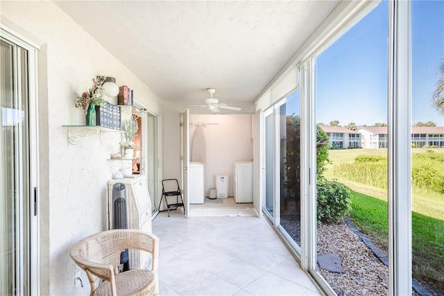 sunroom / solarium featuring independent washer and dryer and ceiling fan