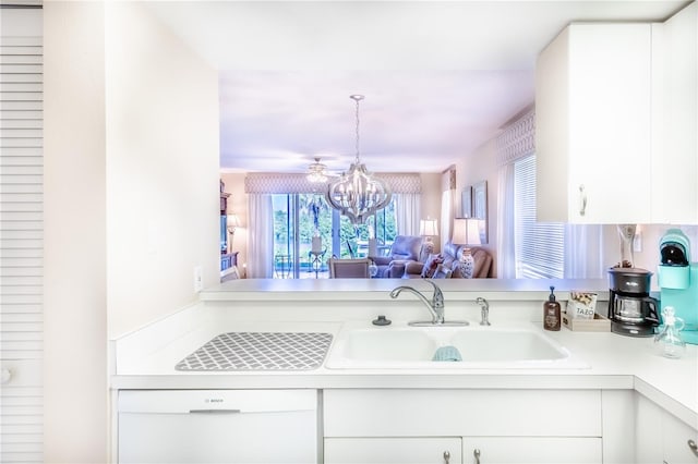 kitchen with sink, white cabinets, and an inviting chandelier