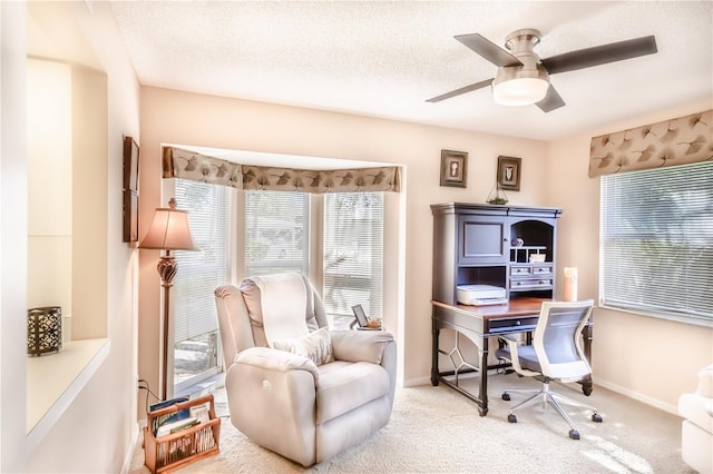 carpeted office space with a textured ceiling and ceiling fan