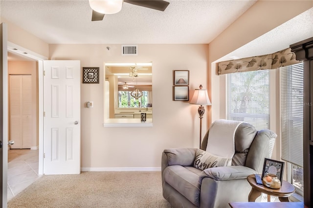 living area featuring sink, ceiling fan, light colored carpet, and a textured ceiling