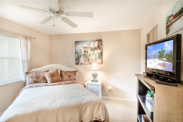 bedroom with a textured ceiling, carpet floors, and ceiling fan