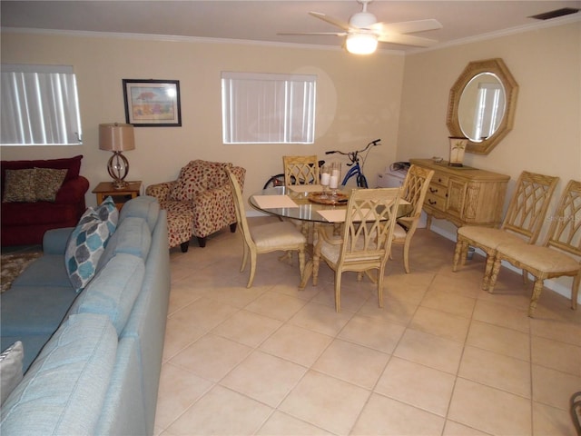 tiled dining area featuring ceiling fan and ornamental molding