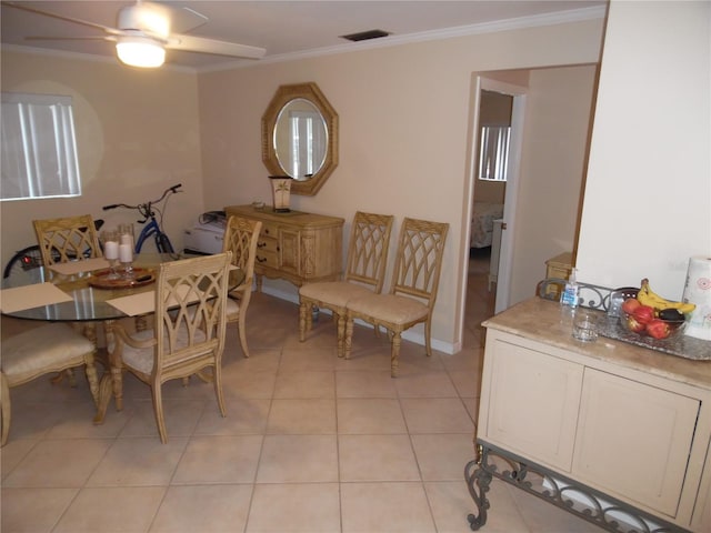 dining room featuring ceiling fan, crown molding, and light tile patterned flooring