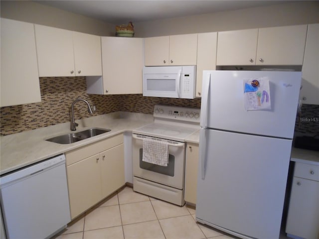 kitchen featuring white appliances, backsplash, white cabinetry, and sink