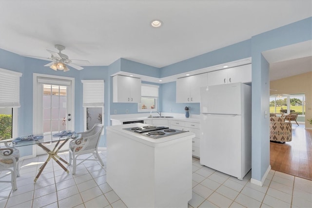 kitchen featuring white cabinets, light tile patterned floors, white refrigerator, and sink