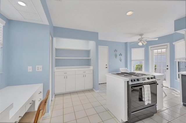 kitchen featuring light tile patterned floors, white cabinetry, ceiling fan, and gas range gas stove