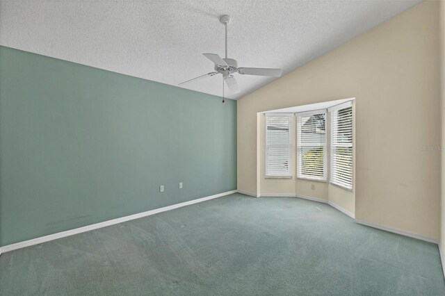 carpeted spare room with a textured ceiling, vaulted ceiling, and ceiling fan