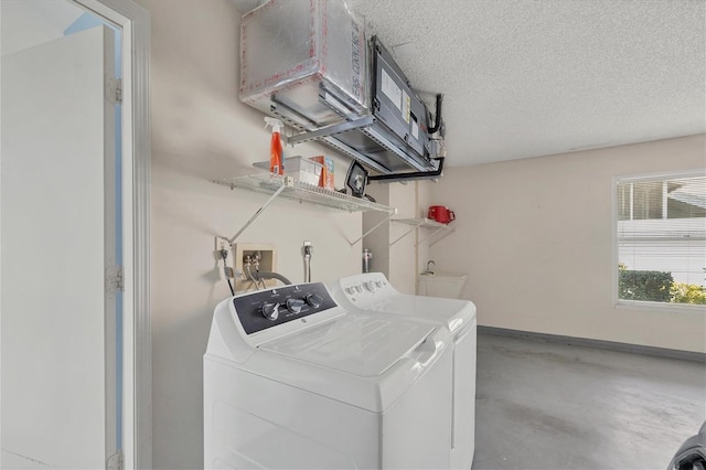 laundry area with a textured ceiling and washing machine and dryer