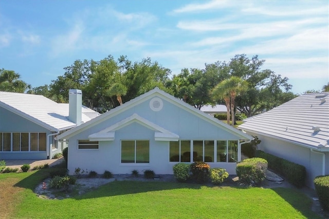 back of house with a lawn and a sunroom