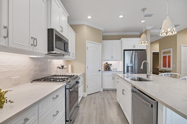 kitchen featuring stainless steel appliances, white cabinets, hanging light fixtures, and sink