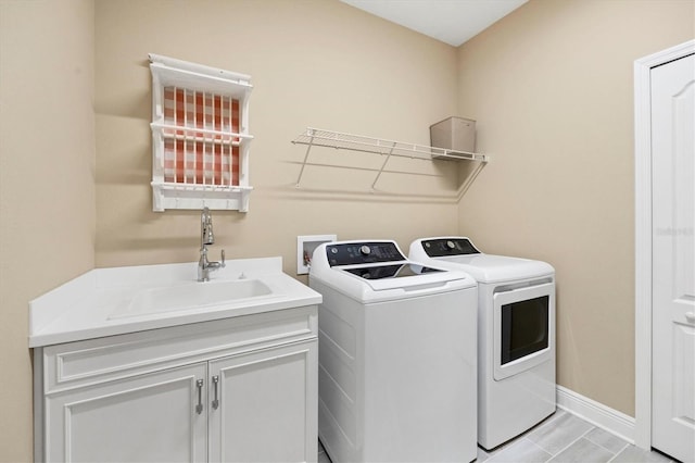 laundry area featuring sink, light tile patterned flooring, independent washer and dryer, and cabinets