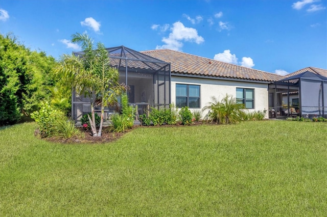 back of house with a lanai and a yard