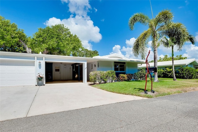 single story home featuring a garage, a front yard, and a carport