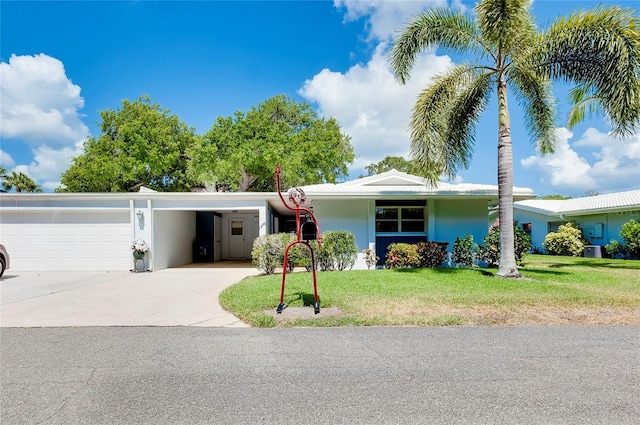 ranch-style home featuring a garage, central AC, and a front yard