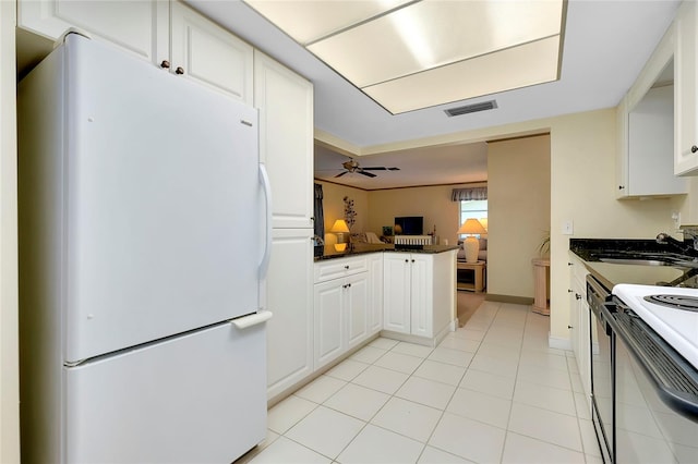 kitchen with white refrigerator, white cabinets, ceiling fan, and light tile floors