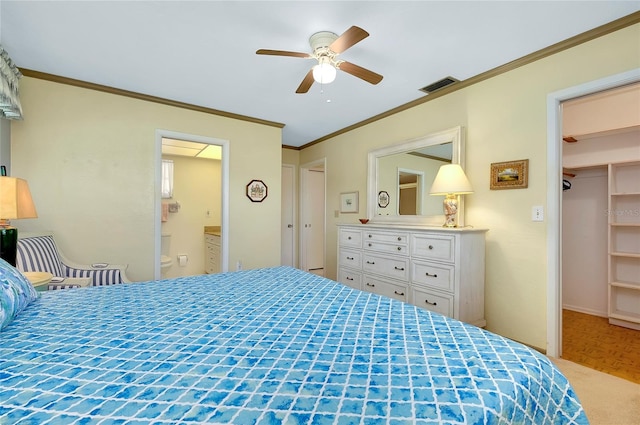 bedroom featuring parquet floors, ceiling fan, crown molding, a walk in closet, and connected bathroom