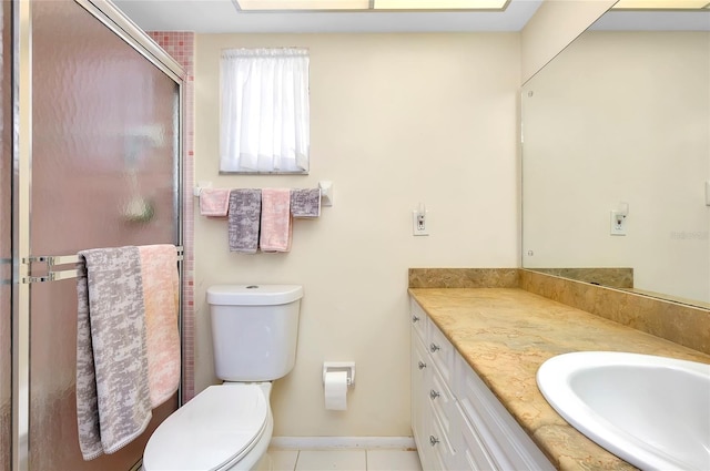 bathroom featuring walk in shower, vanity, toilet, and tile patterned flooring