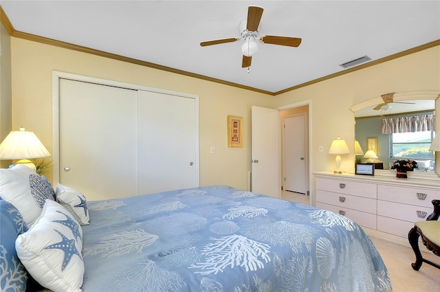 bedroom featuring crown molding, light colored carpet, ceiling fan, and a closet