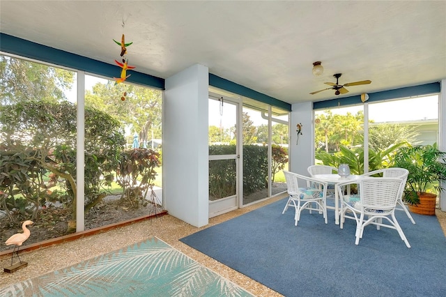 sunroom featuring ceiling fan and plenty of natural light