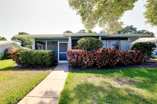 view of front of property with a front yard and ceiling fan