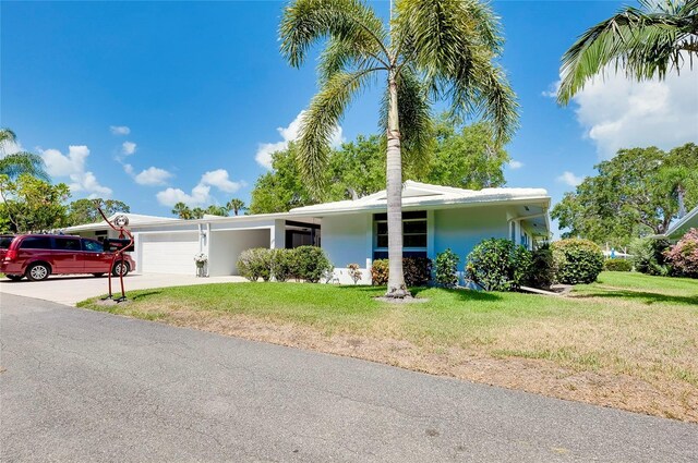 view of front of house featuring a garage and a front lawn