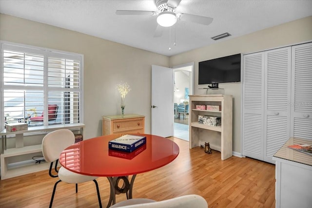 interior space featuring ceiling fan, light hardwood / wood-style flooring, and a textured ceiling