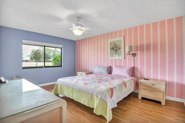 bedroom featuring hardwood / wood-style floors, a textured ceiling, and ceiling fan