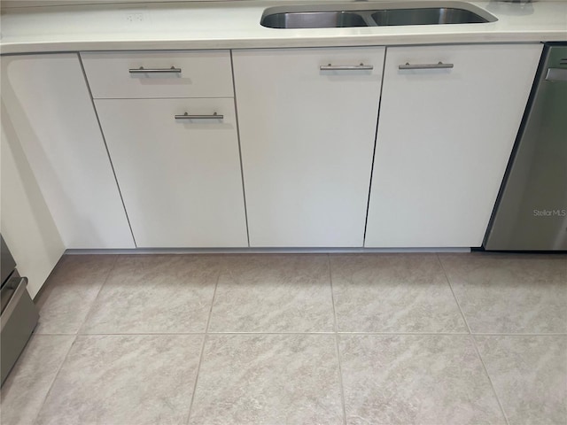 interior details featuring sink, stainless steel dishwasher, and white cabinets