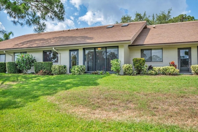 rear view of house featuring a yard