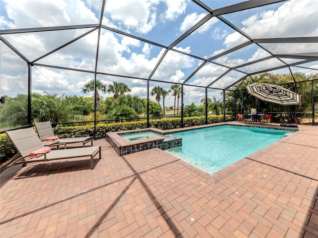 view of pool with a lanai, a patio area, and an in ground hot tub