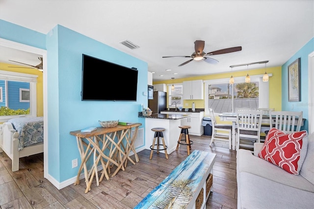 living room featuring ceiling fan and light wood-type flooring