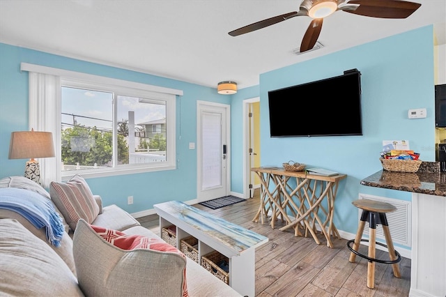 living room with ceiling fan and light wood-type flooring