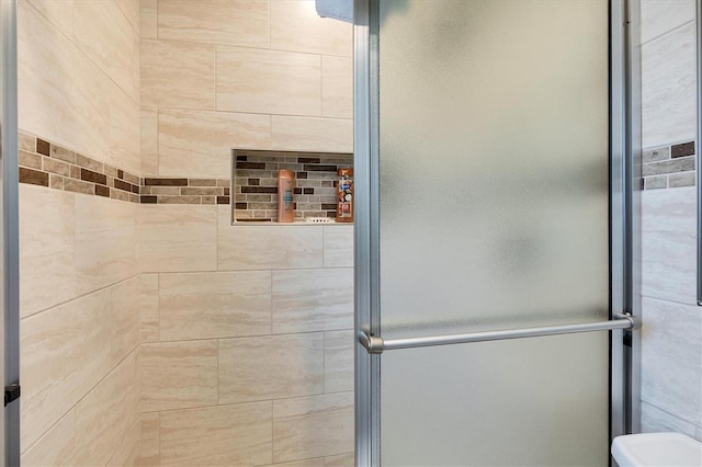 bathroom featuring a shower with door