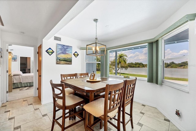 dining space with a notable chandelier, visible vents, and baseboards