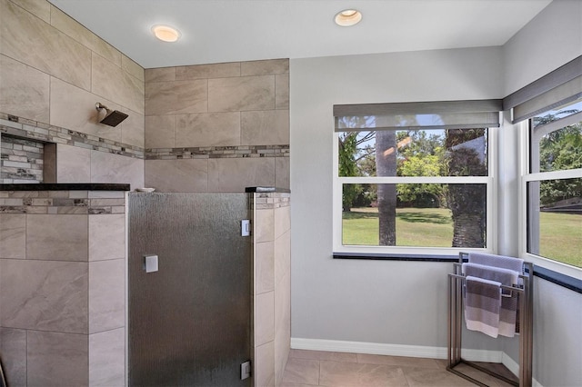 bathroom with baseboards, a stall shower, and tile patterned flooring